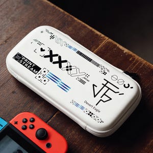 Może przedstawiać: Zestaw trzech ceramicznych kubków z nakrapianym, matowym wykończeniem. Kubki są w odcieniach kremowym, jasnoszarym i ciemnoszarym. Każdy kubek ma prosty, minimalistyczny design i zaokrąglony uchwyt. Odpowiednie do kawy, herbaty lub innych napojów.