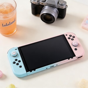 Op de afbeelding: Een set van drie keramische mokken met een gespikkelde, matte afwerking. De mokken zijn in tinten crème, lichtgrijs en donkergrijs. Elke mok heeft een eenvoudig, minimalistisch ontwerp, perfect voor koffie of thee.