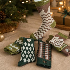 May include: A collection of crew socks featuring various patterns including brown and white mountain zigzags, green and white diamonds, and brown and green geometric triangles. One sock is displayed upright, while others are folded flat.
