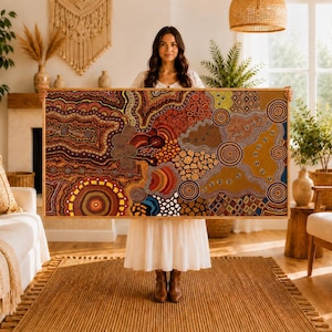 May include: A large rectangular wall art piece featuring an intricate dot painting with earthy tones of red, orange, yellow, brown, and blue. The artwork displays concentric circles, wavy lines, and geometric patterns within a light wooden frame.
