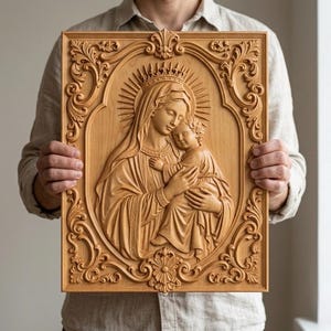 May include: A rectangular light brown wooden wall plaque featuring a detailed relief carving of a woman holding a child. The central figures are surrounded by an ornate, symmetrical scrollwork border with decorative floral and leaf motifs.