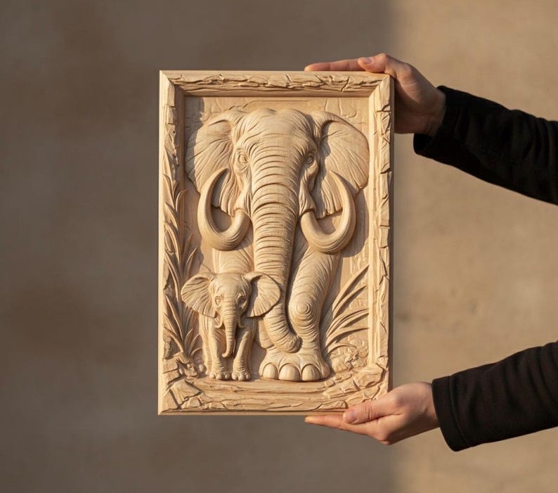May include: A wooden relief carving of an adult elephant and a baby elephant within a rectangular frame. The carving showcases detailed features, including tusks and skin texture. The artwork is presented in a natural wood tone, highlighting the carved details.