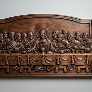 Può includere: Una placca da parete in legno marrone scuro con un dettagliato intaglio in rilievo dell'Ultima Cena. La scena raffigura tredici figure sedute a un lungo tavolo con tessuto drappeggiato, centrate attorno a una figura centrale con un'aureola.