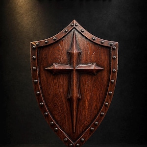 May include: A dark brown wooden shield featuring a central raised cross design and a border accented with small metal studs. The text STL Model is displayed in gold lettering above the shield, which has a visible wood grain texture.