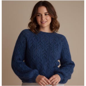 Könnte beinhalten: Ein blauer Strickpullover mit einem detaillierten Blattmuster. Der Pullover hat lange Ärmel und einen Rundhalsausschnitt. Der Stoff wirkt weich und die Farbe ist ein tiefer Blauton.