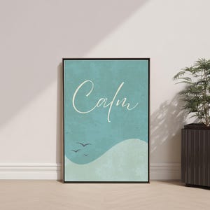 May include: A framed art print with the word "Calm" in elegant cursive script against a teal background. The artwork features a stylized wave and three birds in flight, evoking a sense of tranquility. The frame is black.