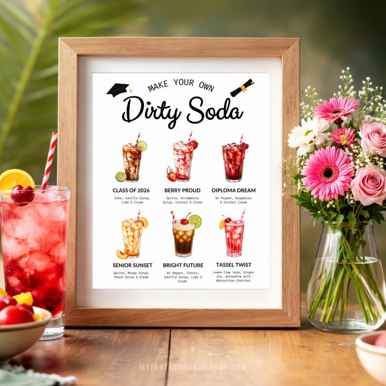 May include: A framed print with the text "Make Your Own Dirty Soda" and illustrations of six soda recipes. The print is in a wooden frame, with a glass of soda and flowers in the foreground.