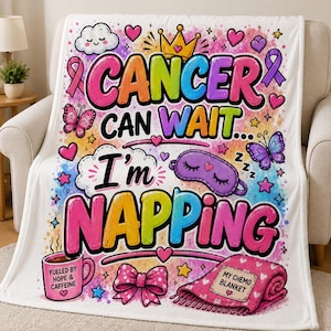 Pode incluir: Uma manta de lã branca com texto colorido que diz CANCER CAN WAIT... I'm NAPPING. O design inclui uma coroa amarela, máscara de dormir roxa, borboletas cor-de-rosa, corações, estrelas, uma caneca com o rótulo FUELED BY HOPE & CAFFEINE e uma manta cor-de-rosa com o rótulo MY CHEMO BLANKET.