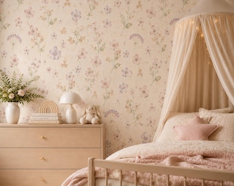 Puede incluir: Un dormitorio con papel tapiz floral de flores rosas, moradas y verdes. Una cómoda de madera clara sostiene un jarrón blanco con vegetación, un arcoíris de madera, libros, una lámpara blanca y un conejo de peluche. Una cama tiene un dosel.