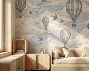 Puede incluir: Una habitación con un mural de globos aerostáticos en tonos azules, grises y beige. La habitación cuenta con muebles de madera clara, incluyendo una cama, armarios y un asiento junto a la ventana. Una alfombra tejida cubre el suelo.