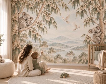 Puede incluir: Un mural de pared con un paisaje pintado de eucaliptos, koalas y cacatúas volando. La escena muestra un valle fluvial con montañas distantes en tonos tierra suaves y apagados. La obra de arte cubre toda la pared detrás de una cuna de madera.
