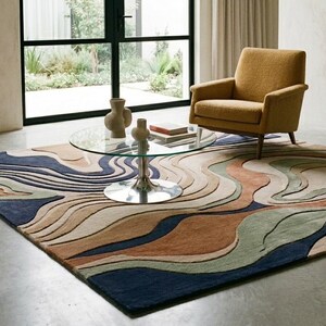 May include: A large rectangular area rug featuring a multi-layered, wavy topographic pattern in shades of navy blue, sage green, terracotta, beige, and cream. The rug has a textured, carved pile surface that creates depth and dimension across the floor.