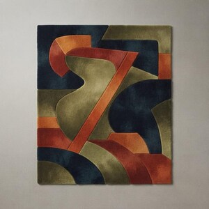 May include: A rectangular area rug featuring a geometric abstract pattern with deep navy blue, olive green, and burnt orange sections. The design consists of interlocking curved and angular shapes with a textured, tufted pile surface throughout.