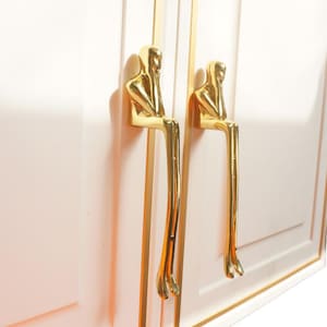 May include: A set of three ceramic mugs with a speckled, matte finish. The mugs are in shades of cream, light gray, and dark gray. Each mug has a simple, minimalist design, perfect for coffee or tea.