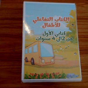 May include: A children's book featuring a yellow bus illustration. The cover displays Arabic text and a bus image in a field. The book is aimed at children aged 2 to 4 years old.