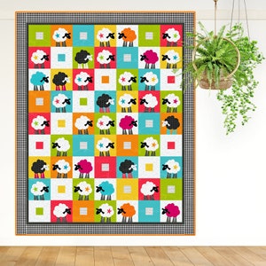 Counting Sheep Quilt Pattern.
Applique sheep and simple square-within-square blocks come together to make a wonderfully whimsical quilt. The quilt is displayed on a white wall.