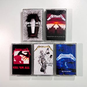 May include: A collection of five Metallica cassette tapes. The tapes feature album art with titles like "Death Magnetic," "Master of Puppets," "Kill 'Em All," "...And Justice for All," and "Ride the Lightning." The cassette cases are clear with various graphic designs.
