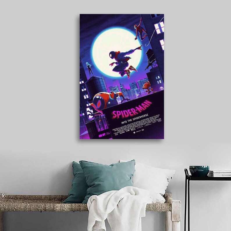 May include: A framed canvas print featuring the animated film "Spider-Man: Into the Spider-Verse." The artwork depicts Spider-Man in action against a cityscape backdrop, with a large moon in the sky. The title is prominently displayed in pink.