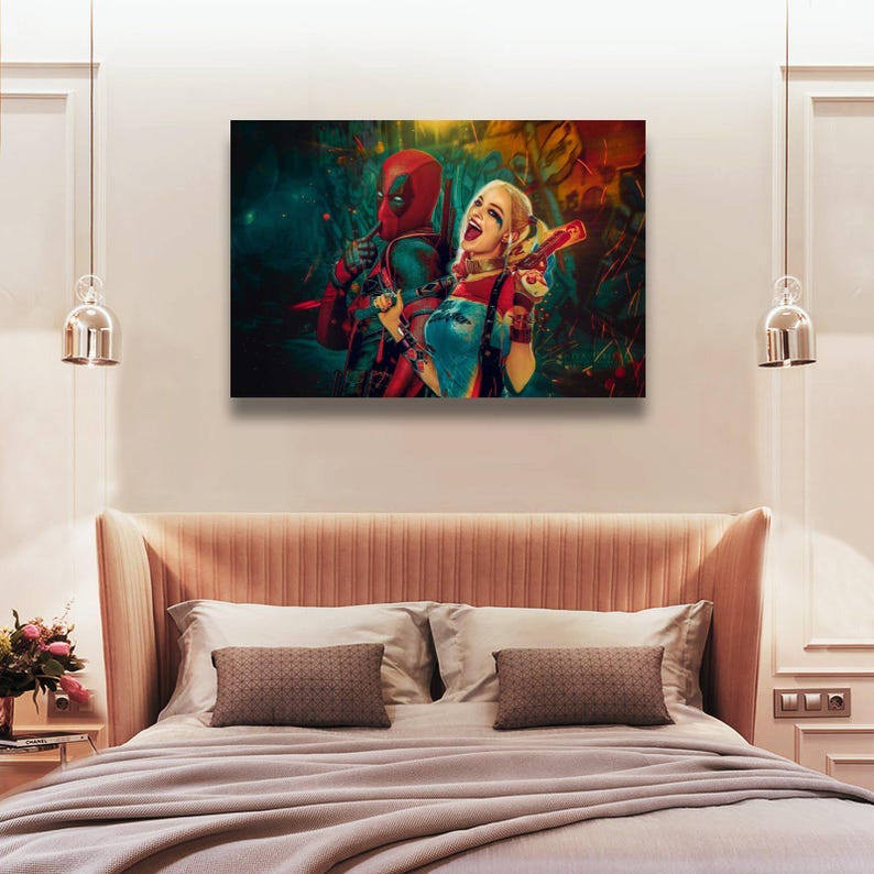 K&ouml;nnte beinhalten: Ein gerahmter Leinwanddruck mit Deadpool und Harley Quinn. Deadpool tr&auml;gt seinen rot-schwarzen Anzug, und Harley Quinn ist in ihrem charakteristischen Outfit und h&auml;lt eine Spielzeugpistole. Das Kunstwerk hat einen lebendigen, farbenfrohen Hintergrund.