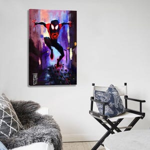 May include: A canvas print featuring a dynamic illustration of a superhero in a black and red suit, leaping through a city scene. The artwork showcases vibrant colors and a sense of movement, with the character's emblem prominently displayed.