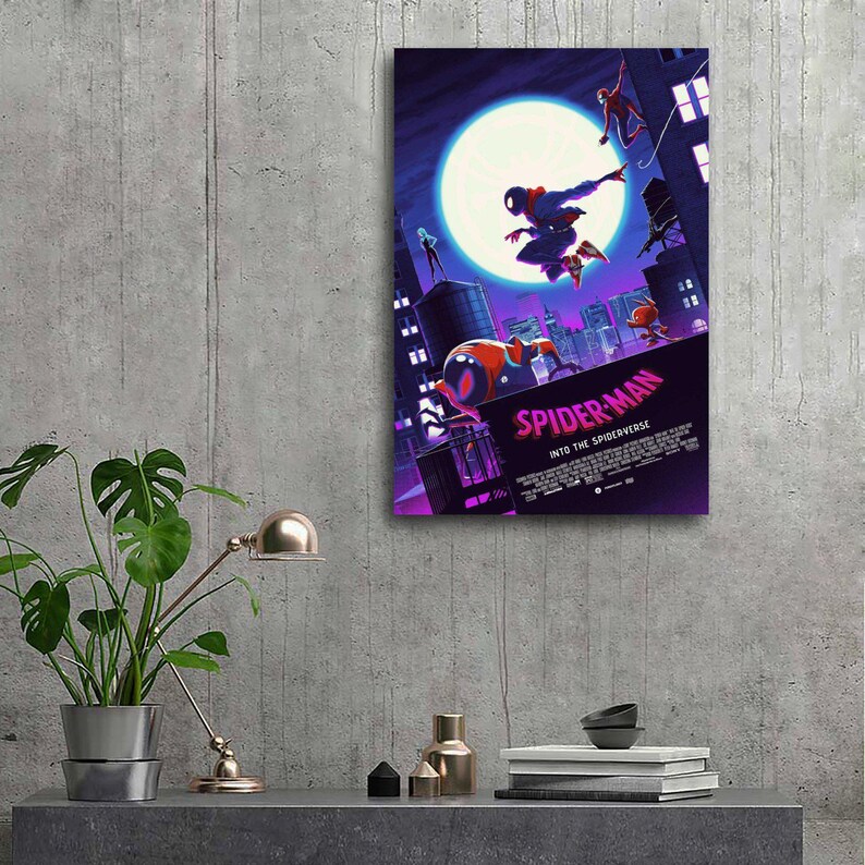May include: A framed poster featuring the animated film "Spider-Man: Into the Spider-Verse." The artwork depicts Spider-Man in action against a cityscape backdrop, with a large moon in the sky. The poster has a purple and blue color scheme.