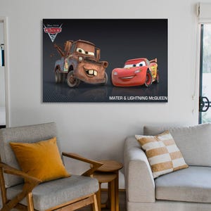May include: A framed canvas print featuring the Disney Pixar Cars characters, Mater and Lightning McQueen, against a dark background. The print includes the Disney Pixar Cars logo and the text "Mater & Lightning McQueen".
