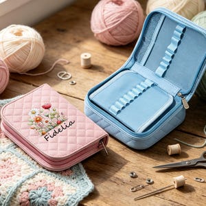 May include: A quilted pink zippered case featuring a floral print and the name Fidelia, alongside an open light blue quilted case with internal elastic loops for organizing tools, both designed for storage and organization of small items.