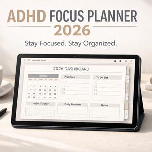 May include: A black tablet showing a 2026 dashboard planner with sections for priorities, to-do lists, and habit tracking. The text "ADHD FOCUS PLANNER 2026" is at the top. A cup of coffee and a pen are also on the table.