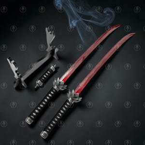 May include: Two swords with vibrant red blades and black handles featuring silver lotus-shaped guards. The set includes a black display stand and a small black handle component. The blades have a wavy pattern and are surrounded by wisps of smoke.