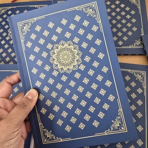 Könnte beinhalten: Stapel marineblauer Einladungskarten mit goldenen geometrischen Mustern und dekorativen Bordüren. Die Karten zeigen ein zentrales Mandala-Design. Die Karten sind wahrscheinlich für eine Hochzeit oder ein besonderes Ereignis.
