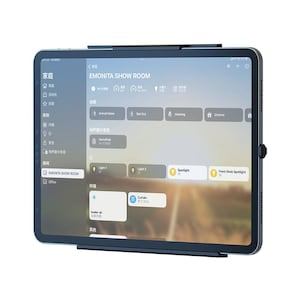 Könnte beinhalten: Ein dunkelgraues Tablet, das eine Smart-Home-Steuerungsoberfläche anzeigt. Der Bildschirm zeigt Optionen für Beleuchtung, Klimatisierung und andere Hausautomationsfunktionen. Der Text "EMONITA SHOW ROOM" ist sichtbar.