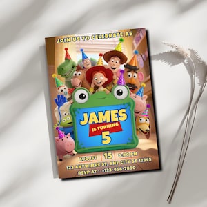 May include: A rectangular birthday invitation card featuring Toy Story characters wearing party hats. A green frog-shaped frame in the center displays the text: JOIN US TO CELEBRATE AS JAMES IS TURNING 5, AUGUST 15, 3:00 PM, 123 ANYWHERE ST, ANY CITY ST 12345, RSVP AT: +123-456-7890.