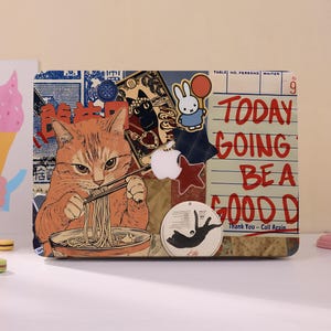 Peut inclure: Un autocollant pour ordinateur portable avec un collage d'illustrations incluant un chat tigré orange mangeant des nouilles, un lapin blanc, un chat noir et un papier ligné avec le texte rouge "TODAY GOING BE A GOOD DAY" et "Thank You -- Call Again."