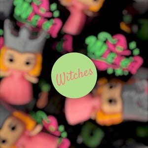 Op de afbeelding: Een herhalend patroon van gestileerde figuren met grijze kronen en roze jurken, afgewisseld met roze en groene tekst die Wicked leest. Een centrale lichtgroene cirkel bevat het woord Witches in een roze cursief lettertype.
