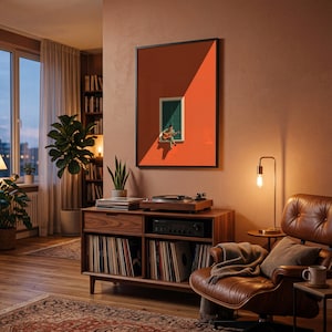 May include: A framed wall art print featuring a minimalist illustration of a person sitting on a window ledge playing an acoustic guitar, set against a vibrant orange wall with green shutters, displayed in a black frame on a warm-toned wall.