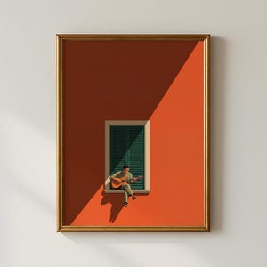 May include: A framed wall art print featuring a person sitting on a window ledge playing an acoustic guitar. The scene is set against a vibrant orange wall with a dark green shuttered window, divided by a sharp diagonal shadow across the composition.