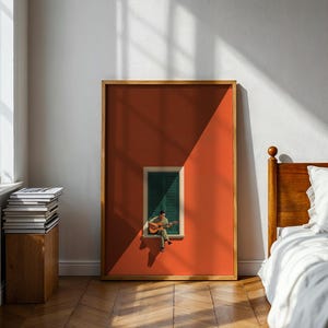 May include: A rectangular framed wall art print featuring a solid burnt orange background with a centered window. The window has dark green louvered shutters and a small figure sitting on the sill playing an acoustic guitar, casting a shadow.