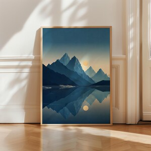 Può includere: Una stampa artistica da parete verticale incorniciata che raffigura una catena montuosa in tonalità blu profondo e blu navy, riflessa in uno specchio d'acqua calmo. Un sole giallo pallido è visibile nel cielo, illuminando le vette.
