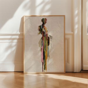 Puede incluir: Impresión artística abstracta con un fondo texturizado blanquecino. La figura está compuesta por rayas verticales en tonos rosa, verde, amarillo y marrón. La obra de arte está enmarcada en un marco de madera clara.