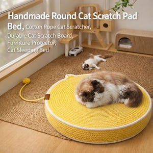 Puede incluir: Una cama redonda amarilla para gatos con un borde blanco, hecha de cuerda tejida. Un gato descansa sobre la cama. La imagen también muestra un rascador para gatos, una cama para gatos y el texto "Handmade Round Cat Scratch Pad Bed, Cotton Rope Cat Scratcher, Durable Cat Scratch Board, Furniture Protector, Cat Sleeping Bed."
