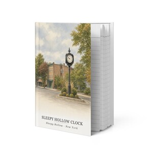 May include: A hardcover notebook featuring a watercolor illustration of a black street clock in Sleepy Hollow, New York. The cover displays the text SLEEPY HOLLOW CLOCK and Sleepy Hollow - New York below the image of the clock and buildings.