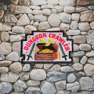May include: Embroidered patch with the words "DUNGEON CRAWLER" in red, featuring a treasure chest overflowing with gold coins, two swords, and a stone background. The patch is rectangular with a decorative border.
