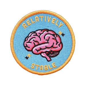 May include: A round embroidered patch with a light blue background and a gold border. The patch features a pink brain graphic and the words "RELATIVELY STABLE" in yellow lettering. Two small black stars are also included.