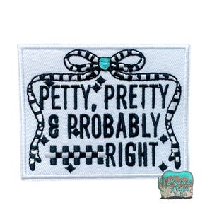 May include: A white rectangular patch with the text "PETTY, PRETTY & PROBABLY RIGHT" in black. The text is framed by a black and white striped design, with a bow at the top and a turquoise accent.