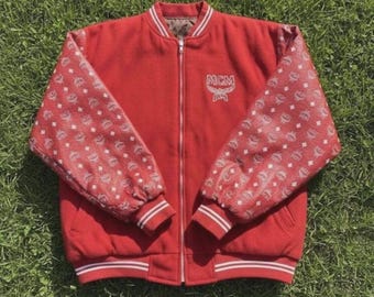 Chaqueta estilo universitario roja inspirada en MCM, bomber con mangas con monograma, estilo streetwear retro con cremallera.