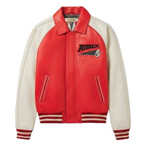 Puede incluir: Chaqueta de cuero roja y crema de estilo bomber. La chaqueta tiene mangas crema y un cuerpo rojo. La parte delantera presenta un parche con la palabra "AVIREX" y un logotipo de cabeza de indio. Los pu&ntilde;os y el dobladillo tienen rayas rojas y blancas.