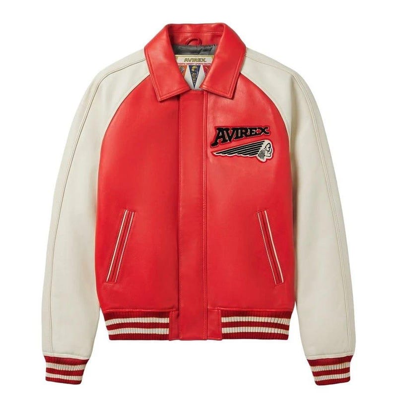 Puede incluir: Chaqueta de cuero roja y crema de estilo bomber. La chaqueta tiene mangas crema y un cuerpo rojo. La parte delantera presenta un parche con la palabra "AVIREX" y un logotipo de cabeza de indio. Los pu&ntilde;os y el dobladillo tienen rayas rojas y blancas.