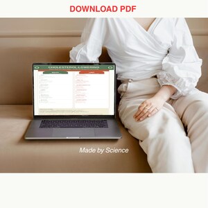 Op de afbeelding: Een laptop met een "Cholesterol-Lowering" gids met de secties "Enjoy" en "Limit". De tekst "DOWNLOAD PDF" staat boven de laptop en "Made by Science" eronder. De laptop staat op een bruin oppervlak.