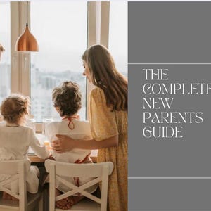 Peut inclure: Une famille de quatre personnes est réunie autour d'une table près d'une fenêtre. Le texte "THE COMPLETE NEW PARENTS GUIDE" est sur le côté droit de l'image. La famille est dans une pièce bien éclairée avec une suspension cuivrée.