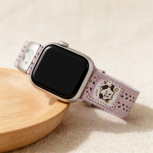 Kawaii pastel Apple watch band attached to a smartwatch with a matching cute cartoon character wallpaper, showcasing a sweet and cozy everyday accessory.